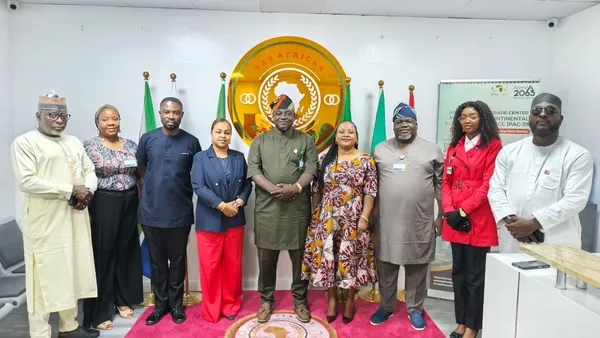 A group photograph at the Mission’s office, with the Pan-African emblem and flags.